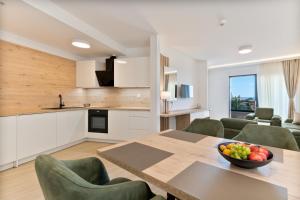 a kitchen and dining room with a table and chairs at Aparthotel Remaneo in Promajna