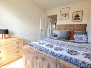 a bedroom with a large bed and a dresser at Homely Three Bed Holiday Home in Glasgow in Glasgow