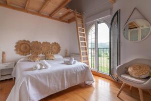 a bedroom with a bed and a chair and a large window at Fidalsa Majestic in Puente Arce