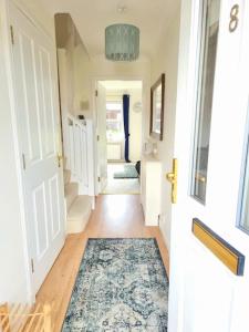 a hallway with a door and a rug on the floor at Homely Three Bed Holiday Home in Glasgow in Glasgow