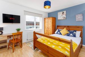 a bedroom with a bed and a desk with a computer at Sunshine Terrace by Happy Sunshine Stay in Manchester