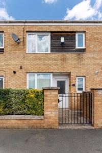 a brick house with a gate and a fence at Sunshine Terrace by Happy Sunshine Stay in Manchester