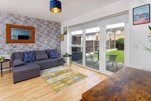 a living room with a couch and a brick wall at Sunshine Terrace by Happy Sunshine Stay in Manchester