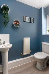 een blauwe badkamer met een toilet en een wastafel bij Sunshine Terrace by Happy Sunshine Stay in Manchester