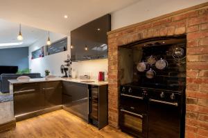 a kitchen with an oven and a brick wall at Village Retreat & Hot Tub Nr Bicester Village in Bucknell