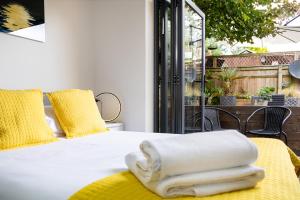 a bedroom with a white bed with yellow pillows at Village Retreat & Hot Tub Nr Bicester Village in Bucknell