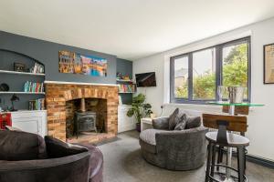 sala de estar con 2 sillas y chimenea en Village Retreat & Hot Tub Nr Bicester Village en Bucknell