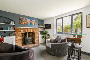 a living room with two chairs and a fireplace at Village Retreat & Hot Tub Nr Bicester Village in Bucknell