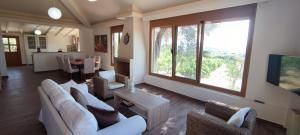 sala de estar con muebles blancos y ventana grande en Ellie's StoneHouse Gianapa, Porto Rafti, Greece, 190 03, GR, en Porto Rafti