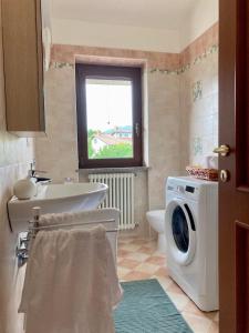 a bathroom with a washing machine and a sink at LOVE NEST Abruzzo in Scoppito