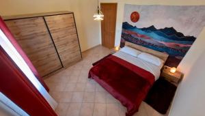 a bedroom with a red bed with a painting on the wall at LOVE NEST Abruzzo in Scoppito