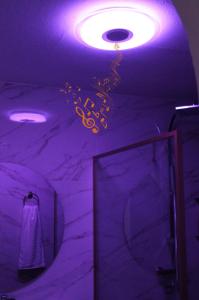 a bathroom with purple lighting and a shower with a mirror at NatureHouse in Campo Maior