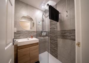 ein Bad mit einer Dusche, einem Waschbecken und einem Spiegel in der Unterkunft The Hideaway Sherburn in Elmet in Sherburn in Elmet