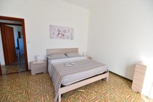 um quarto com uma cama num quarto branco em La Terrazza sugli Dei em Pianillo
