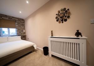 a bedroom with a crib and a clock on the wall at The Hideaway Sherburn in Elmet in Sherburn in Elmet