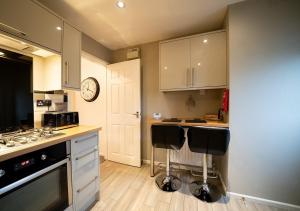 a kitchen with white cabinets and black appliances at The Hideaway Sherburn in Elmet in Sherburn in Elmet