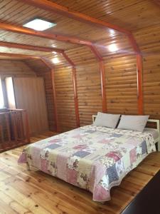 um quarto com uma cama num chalé de madeira em Домик для отдыха рядом Днепр em Cherkasy