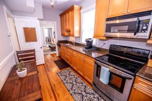 La cuisine est équipée de placards en bois et d'un four avec plaques de cuisson. dans l'établissement King George Downtown Annapolis Getaway, à Annapolis