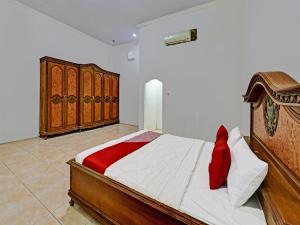 Schlafzimmer mit einem Holzbett und Holzschränken in der Unterkunft OYO 3479 Hotel Intan in Banyumas