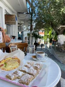 einen Tisch mit einem Teller Essen und einer Tasse Kaffee in der Unterkunft Studio Cozy - In the Heart of Skyros Village in Skyros