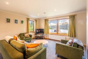 uma sala de estar com dois sofás e uma mesa em Langridge Highland Home em Badcaul