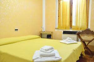 a bedroom with a yellow bed with towels on it at Il Mandriano in Carpegna +4 photos