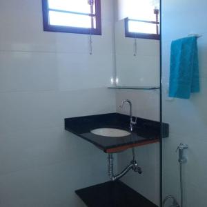 uma casa de banho com um lavatório preto e uma janela em Pousada Epicurista em Capitólio