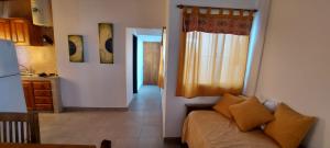 Una sala de estar con una cama y una cocina. en DEPARTAMENTO ORTEGA Junin, en Junín 9 fotos más
