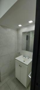 a white bathroom with a sink and a mirror at DEPARTAMENTO ORTEGA Junin in Junín