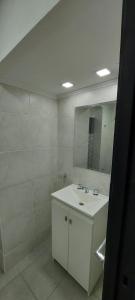 Un baño blanco con lavabo y espejo. en DEPARTAMENTO ORTEGA Junin, en Junín