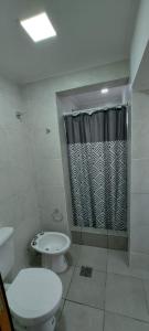 Un baño con inodoro y cortina de ducha. en DEPARTAMENTO ORTEGA Junin, en Junín