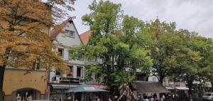 uma rua com árvores e um edifício branco em Stylische 2-Zimmer Wohnung - Balkon - Parkplatz - Smart TV - Arbeitsplatz em Friedberg