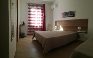 ein Schlafzimmer mit einem Bett und einem roten Vorhang in der Unterkunft Aquilone in Castelluzzo