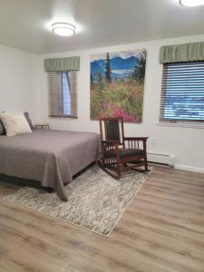 Alaska Country Inn في Delta Junction: غرفة نوم بسرير وكرسي ودهان