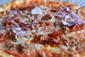 a pizza with meat and onions on a plate at Il Mandriano in Carpegna