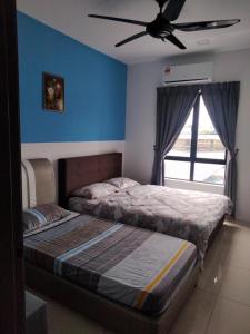 a bedroom with two beds and a ceiling fan at KH Water Park Manhattan Condo Ipoh Homestay in Kampong Pinji