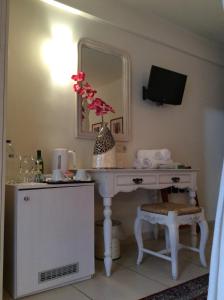 ナフプリオにあるAerinon Guesthouseの白いデスクと鏡が備わる客室です。