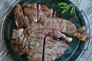 a plate of steak on a table with a pile of meat at Il Mandriano in Carpegna