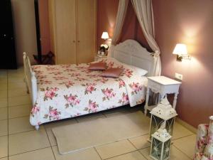 ナフプリオにあるAerinon Guesthouseのピンクの花が飾られた白いベッドが備わるベッドルーム1室