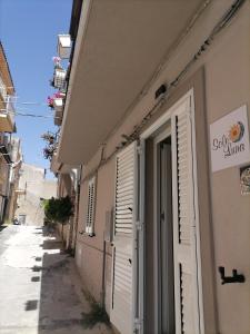 a building with white shutters on the side of a street at SoleLuna Apartment 2 in Santa Elisabetta