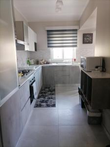 a large kitchen with white cabinets and a window at SoleLuna Apartment 2 in Santa Elisabetta