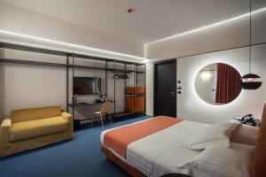 1 dormitorio con 1 cama, 1 silla y TV en Hotel Dimora Del Monaco en Matera