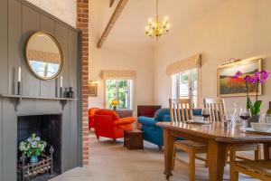 a living room with a table and a fireplace at Luxurious rural retreat - Holt Coach House in Sudbury