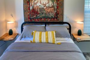 a bed with two lamps and a painting on the wall at 2 Mi to Marinas and Grove Cozy Cabin with Grill in Grove