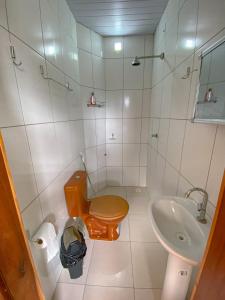 a small bathroom with a toilet and a sink at Pousada Brisa do Mar in Barrinha