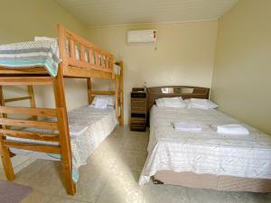 a bedroom with two bunk beds and a ladder at Pousada Brisa do Mar in Barrinha