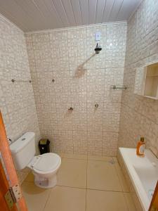 a bathroom with a toilet and a sink and a tub at Pousada Brisa do Mar in Barrinha