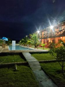 a building with a swimming pool at night at Pousada Brisa do Mar in Barrinha