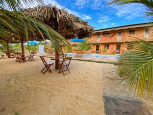 a resort with tables and chairs on the beach at Pousada Brisa do Mar in Barrinha