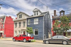 un camion rosso parcheggiato di fronte a una casa blu. di Well-Appointed Pittsburgh Home 1 Mi to Dtwn! a Pittsburgh